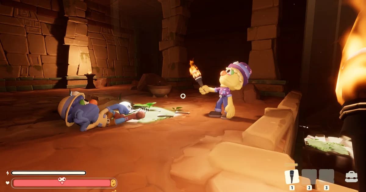 A yellow puppet explorer in a purple beanie holds up a torch beside a knocked-out teammate on a sandstone temple floor