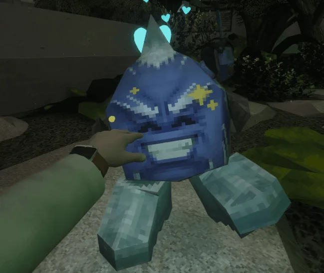 A blue, pixel-textured creature with an angry face and floating hearts being petted by a scientist's hand