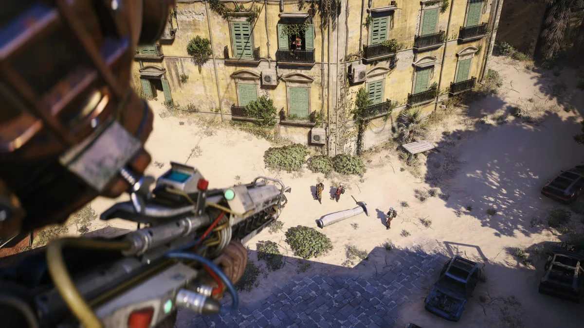A Raider aims down from an elevated rooftop position overlooking a sandy Mediterranean-style courtyard in ARC Raiders, with two other Raiders and dropped loot visible below