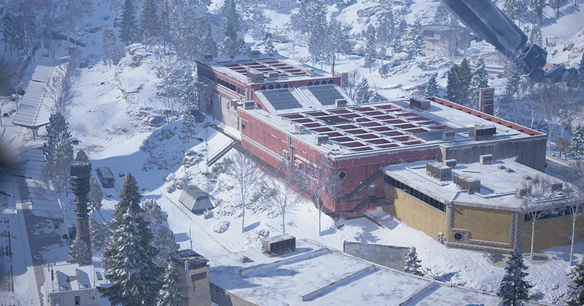 Aerial view of a snowy mountain town in ARC Raiders with a red-brick industrial building and a yellow supermarket among pine trees