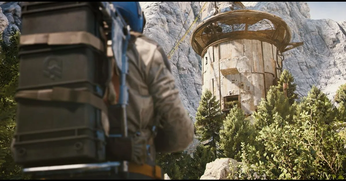 Raider carrying a large backpack stands in the foreground looking at a round weathered tower on a rocky cliff among pine trees
