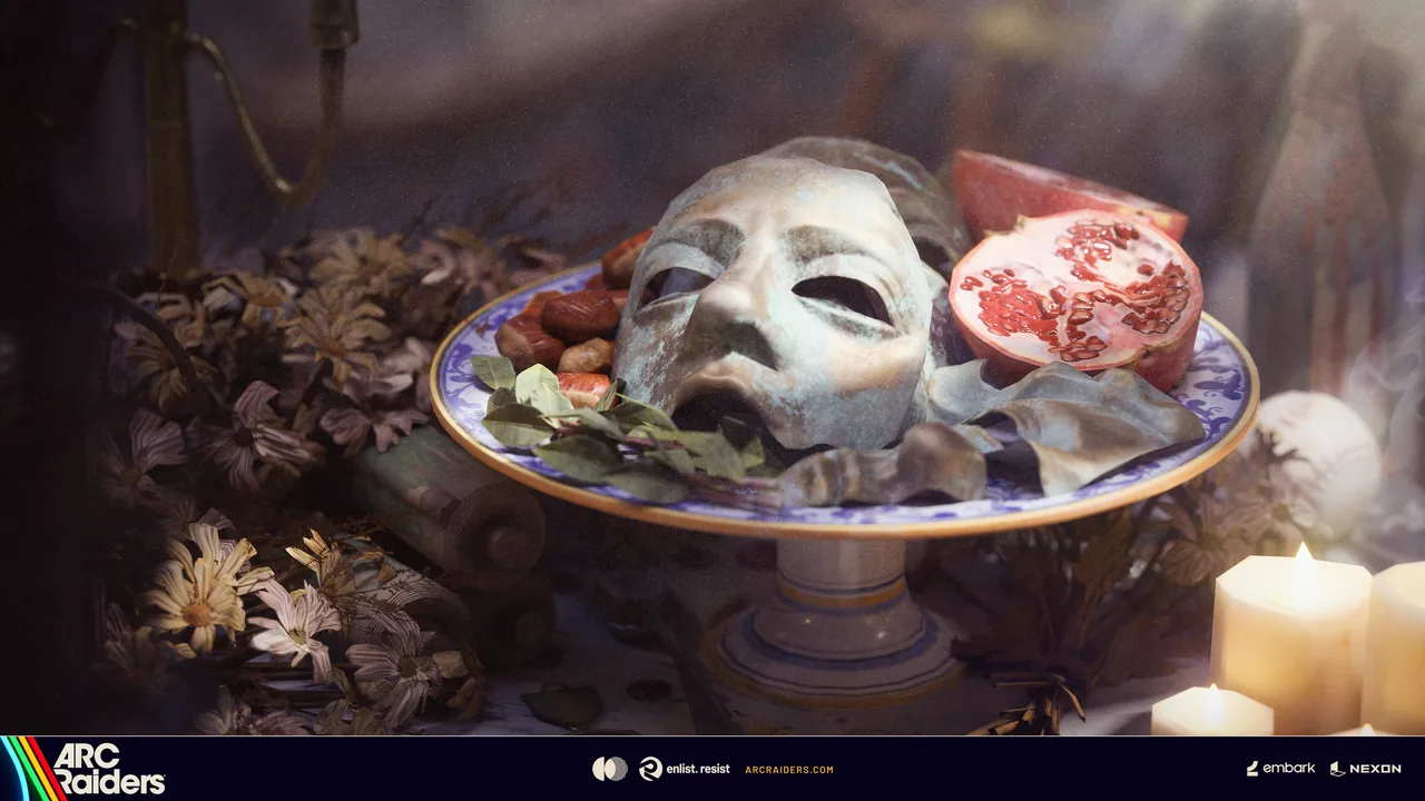 Weathered metal face mask on a blue and white plate beside a split pomegranate and lit candles
