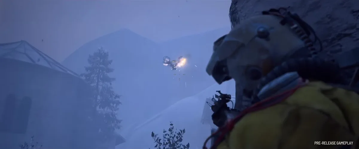 Player in a yellow jacket and round helmet aiming at a small flying drone hit by gunfire over snowy hills