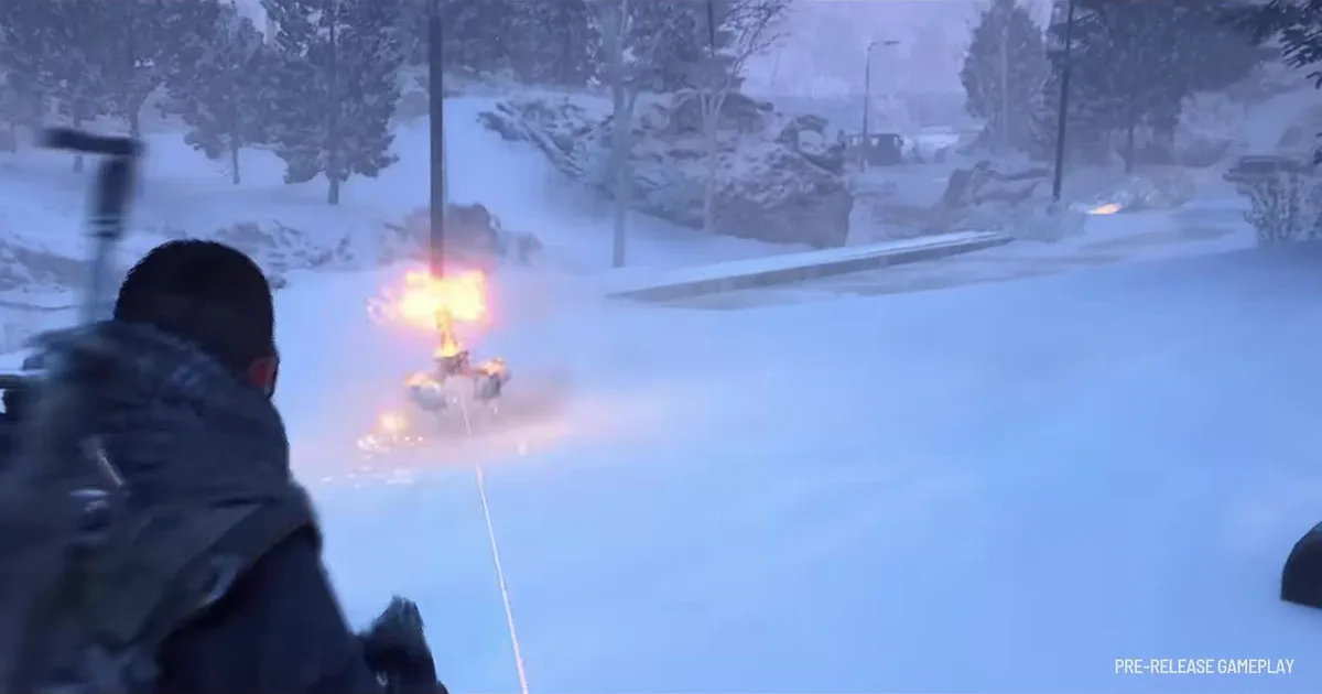 ARC Raiders player with a red backpack firing a rifle at a small ARC machine bursting into flames on a snowy road