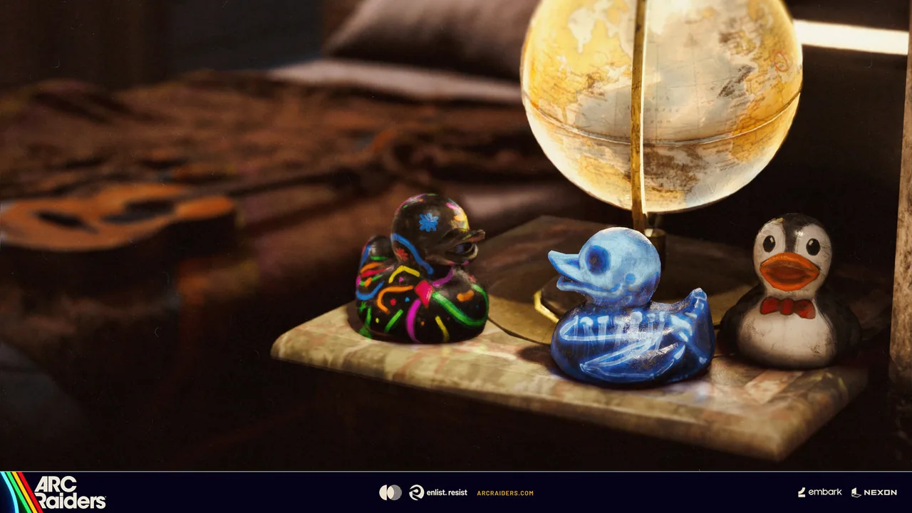 Three rubber ducks, one rainbow-striped, one blue and one white penguin-style, on a desk beside a lit globe
