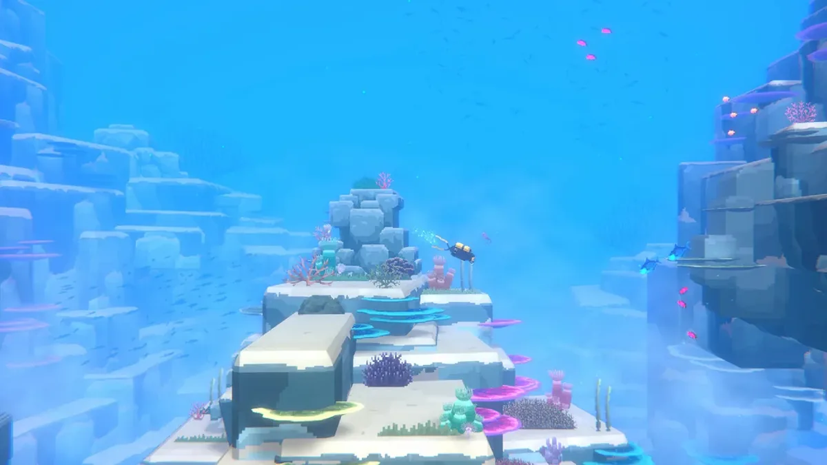 Dave in yellow dive gear swims above a coral-covered rock shelf in bright blue water, with a school of small fish overhead