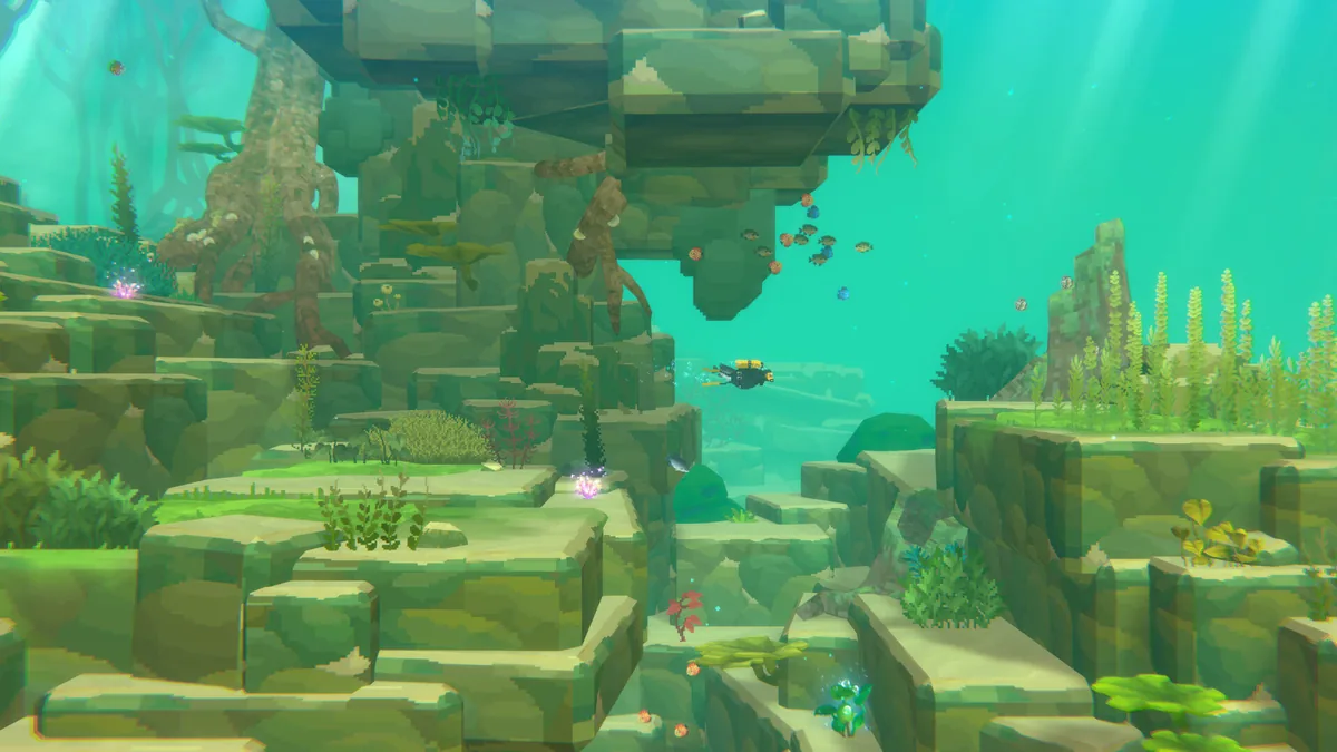 Dave the Diver Jungle DLC underwater lake canyon with rock terraces, tree roots, and small fish schools swimming through teal water
