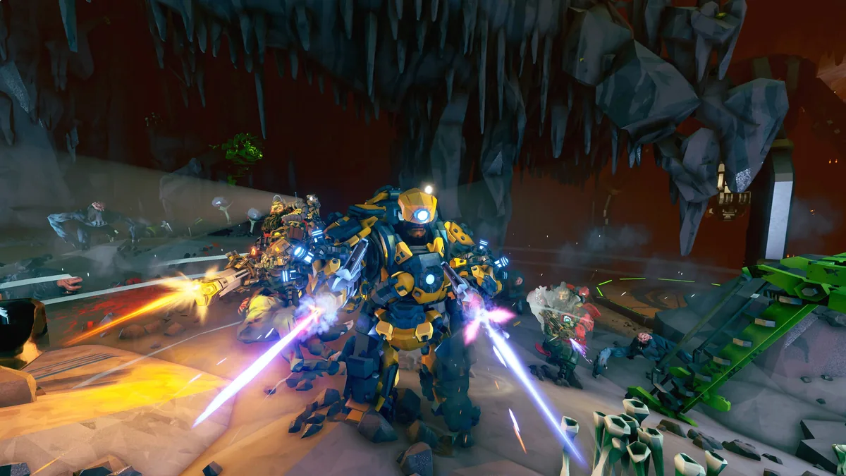 Four armored Reclaimers firing energy weapons in a dark cave, engaging enemies alongside glowing green machinery