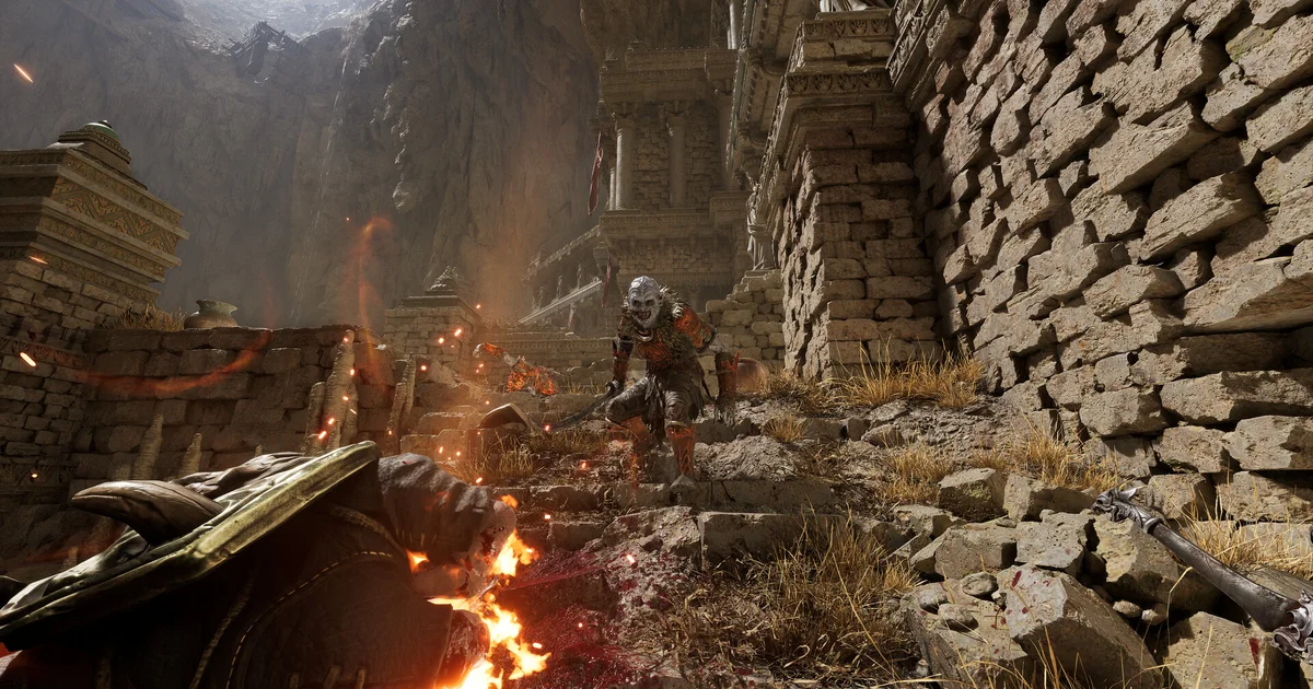 Fatekeeper first-person view of a sword raised against a ruined dark-fantasy hall lit by torchlight
