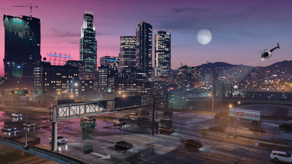 GTA V city skyline at night with wet freeway traffic, downtown towers, hills, and a helicopter