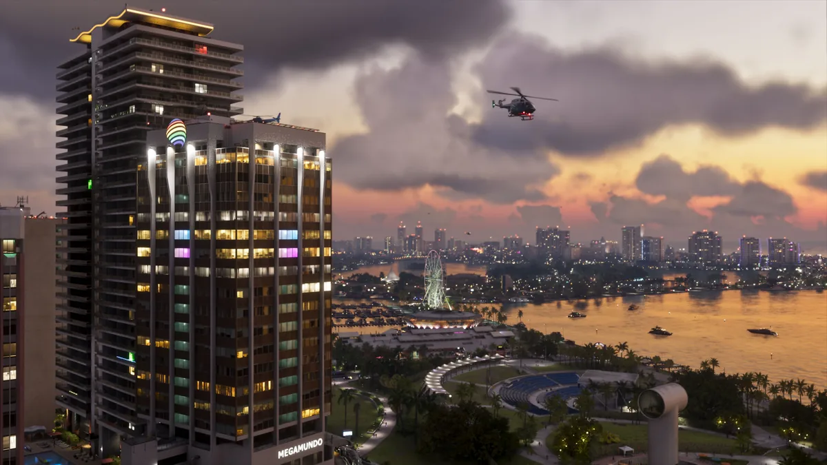 GTA VI Vice City skyline at sunset with waterfront ferris wheel, high-rise apartments, helicopters, and boats