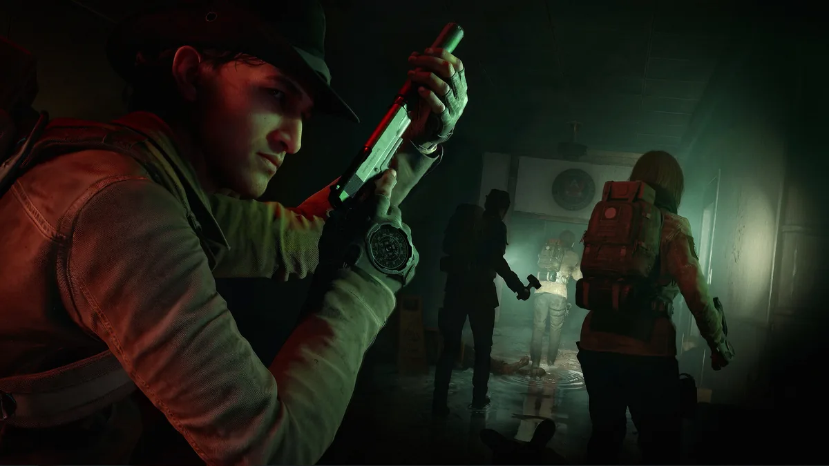 Three Responders with backpacks and a shotgun walk single file through a dim, flooded corridor lit by a handheld light