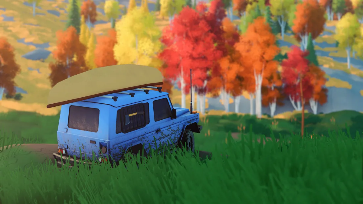 Blue 4x4 with a canoe on its roof stands beside dense autumn trees