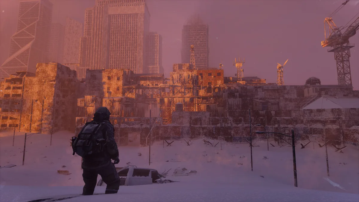 A snow-covered survivor looks across a ruined city while a broken skyline fades into a pink winter sky