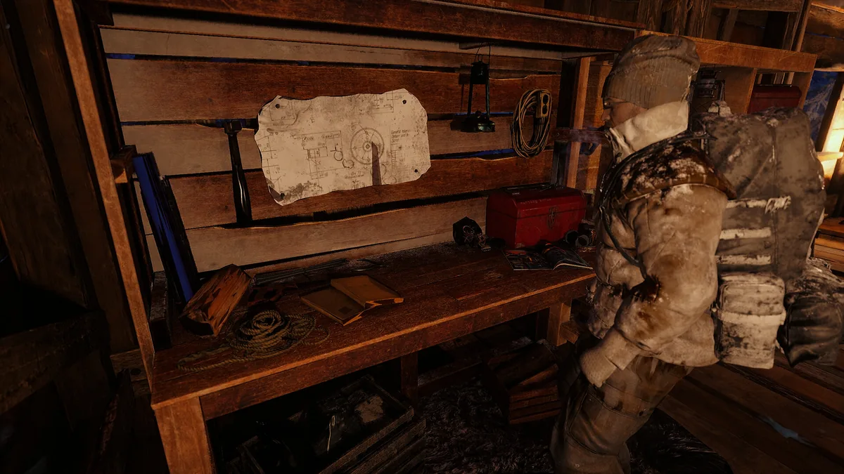 A bundled survivor stands beside a paper map and supplies inside a wooden shelter