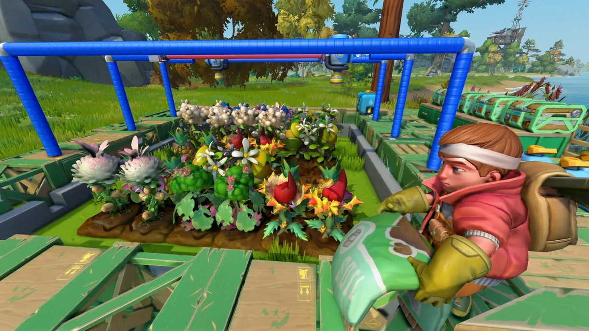 A crop bed irrigated by an overhead rig of blue pipes and sprinkler heads, with a player character holding a bag of seed or fertilizer nearby