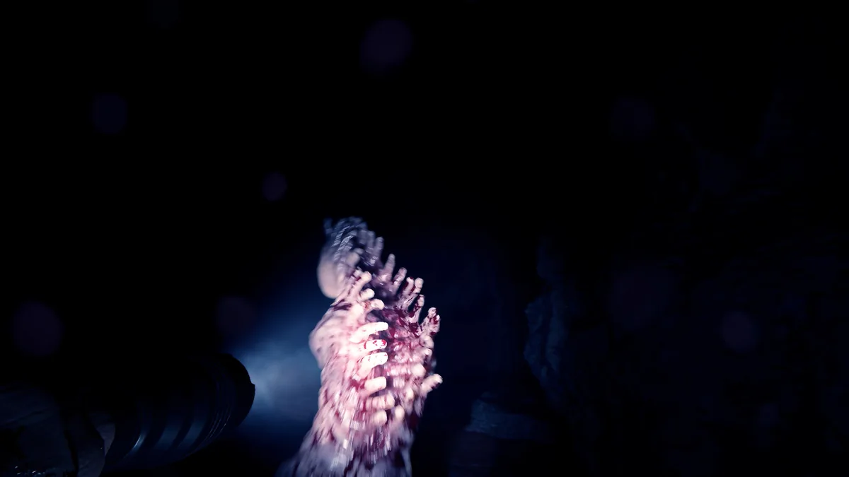 Sons of the Forest dark cave passage with a bloodied clawed hand reaching upward, lit by a dim blue light source