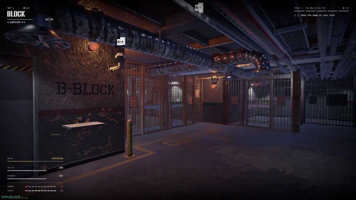 Dark prison cell block with B-BLOCK painted on the wall and cell doors along the back