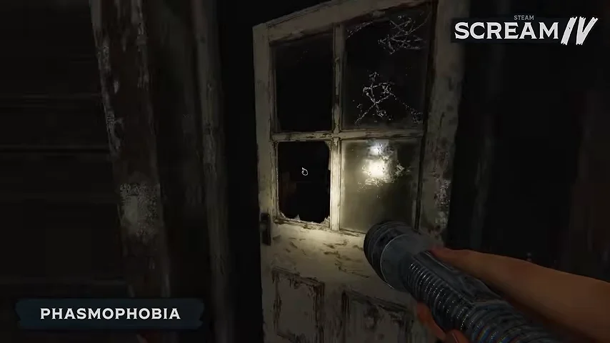 First-person flashlight pointed at a cracked, web-covered door window in a dark wooden house