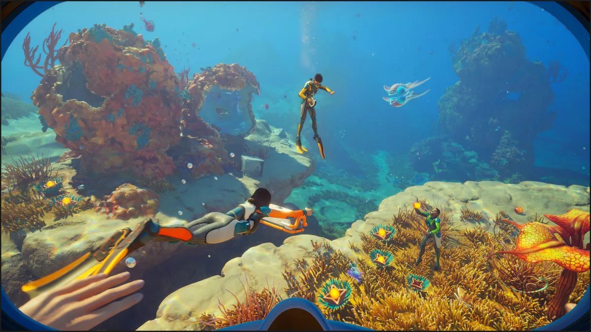 Subnautica 2 underwater co-op exploration scene with divers and alien fauna above a reef
