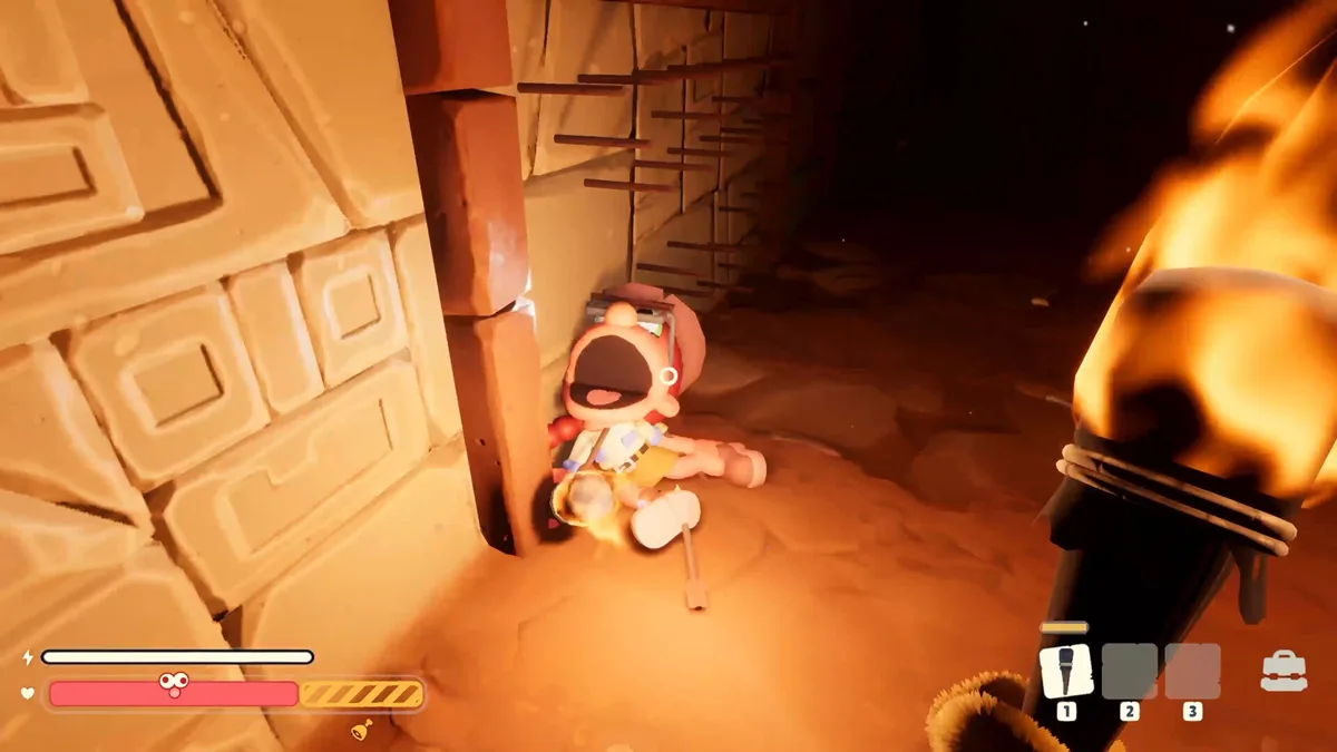 A red-capped explorer slumps screaming against a carved sandstone wall as a torch burns in the foreground
