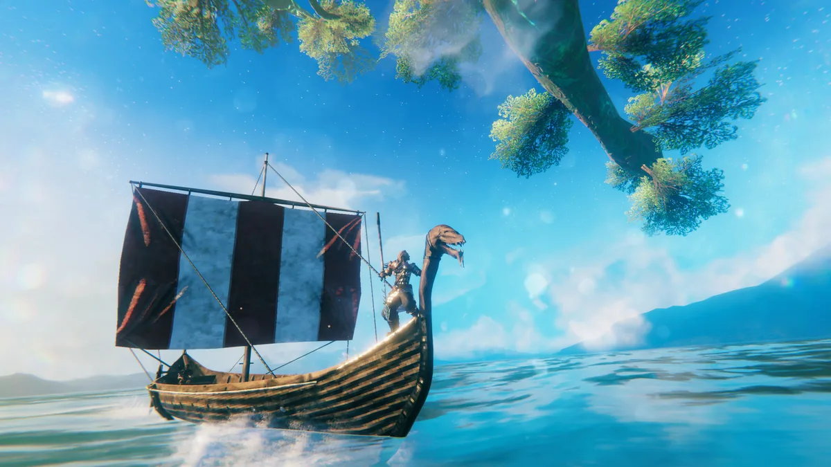 Viking steering a dragon-prowed longship with a striped sail beneath trees on bright blue water