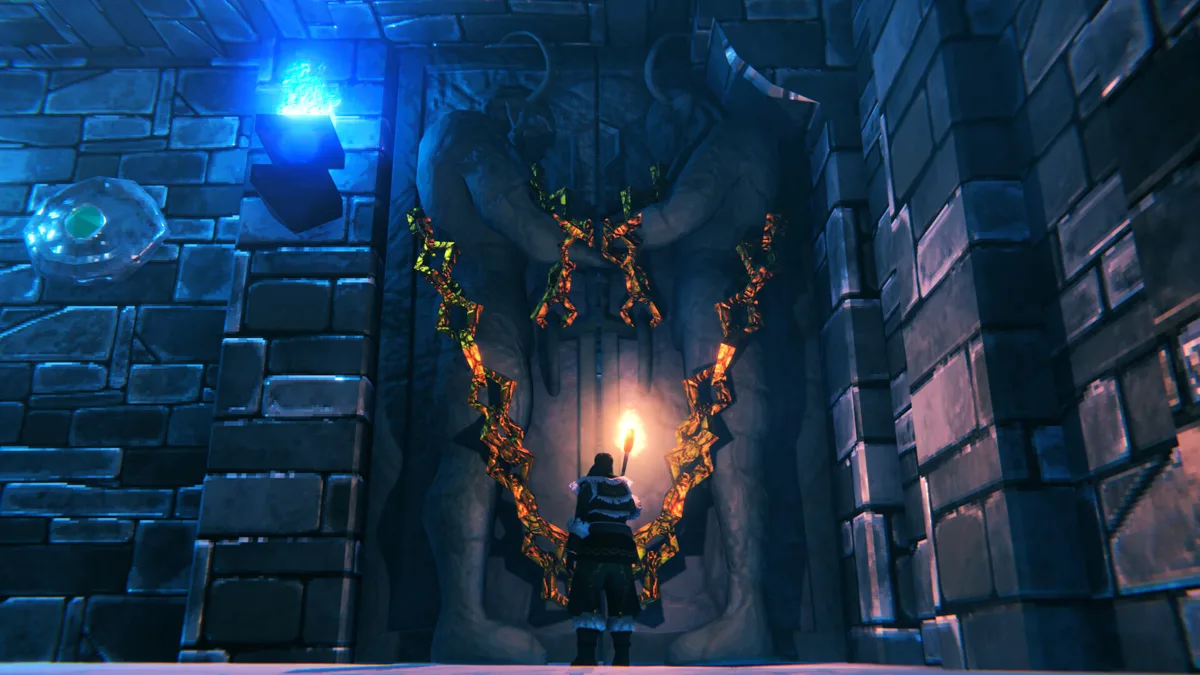 A Viking holding a torch stands before a chained stone gate flanked by carved figures in a blue-lit dungeon