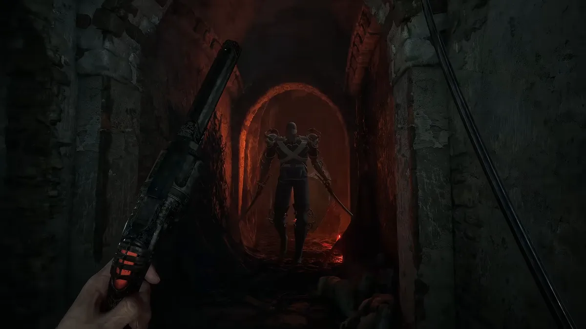 First-person view raising a pistol down a dark stone corridor toward a tall figure standing under a red-lit arch